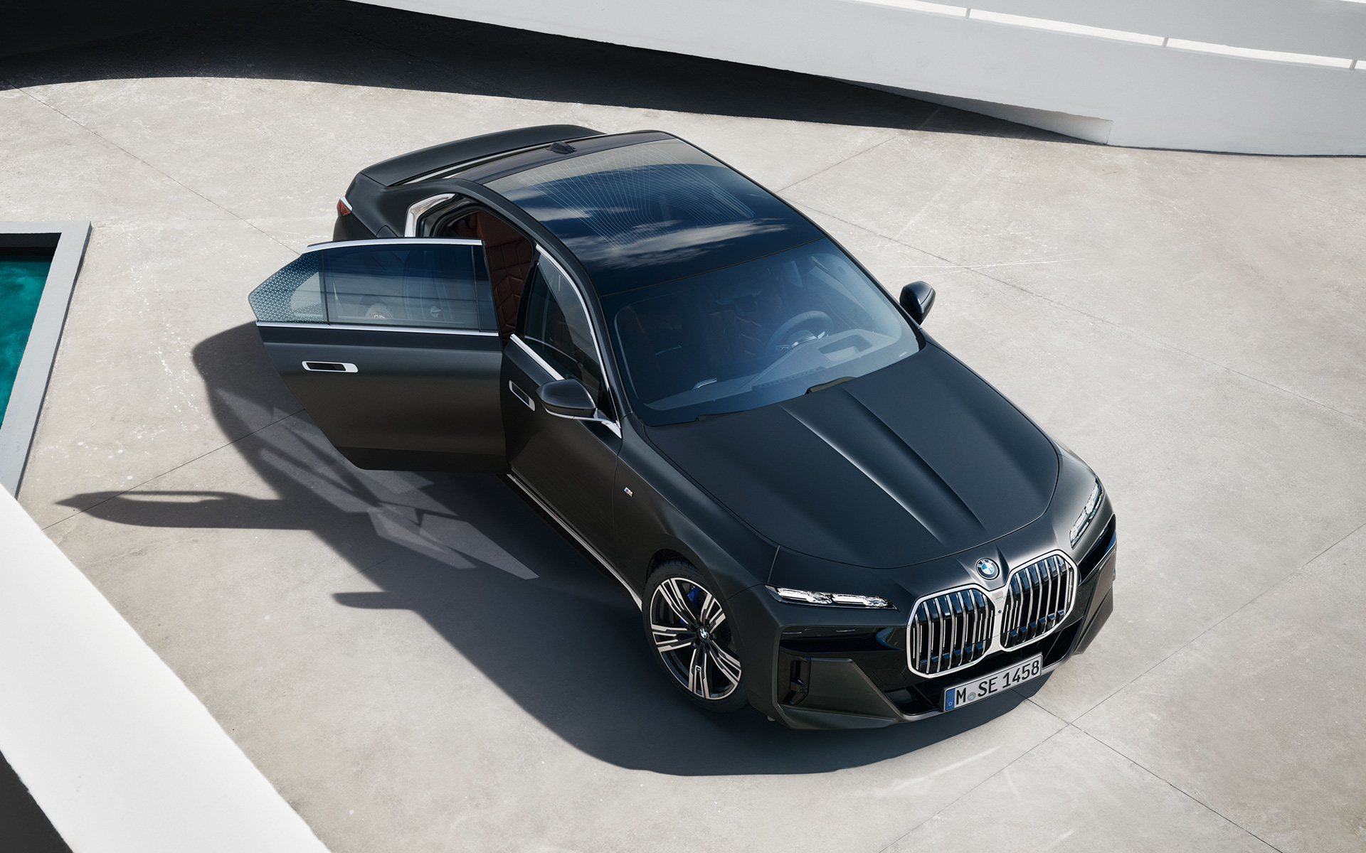 BMW 7 Серии Седан G70 ICE 740i пакет M Sports, окраска кузова серый металлик (Frozen Deep Grey), вид сверху с открытой дверью пассажира